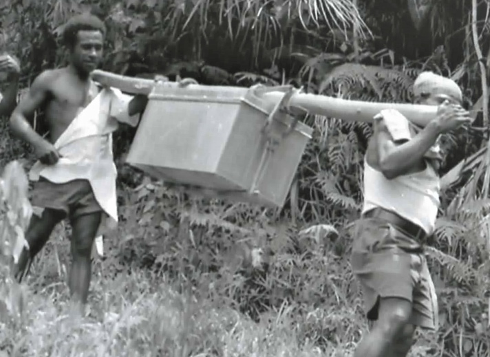 Two men carrying a large box.